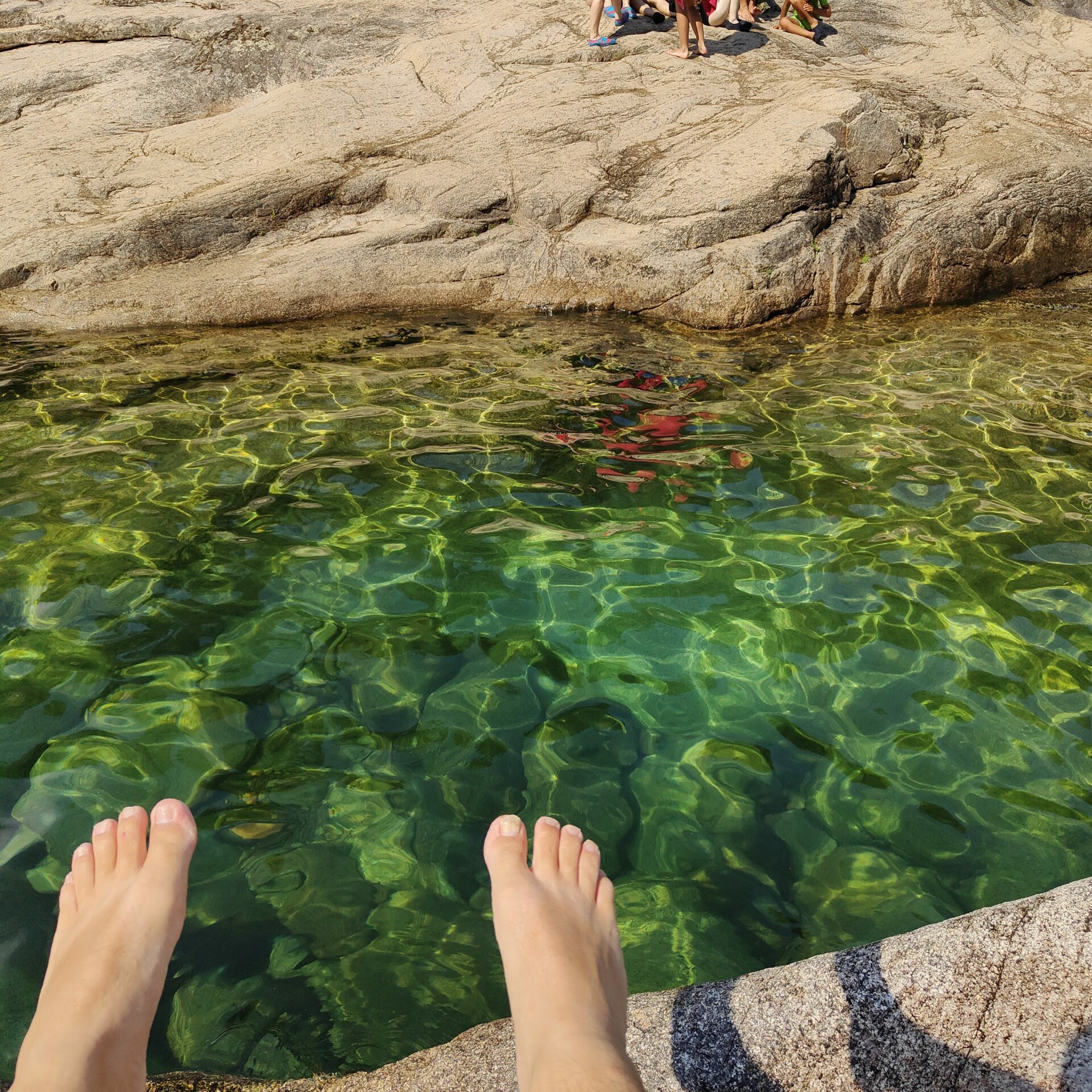 Piscine-de-Cavu-sud-de-Corse-famille-pied-dans-eau-residence-les-trois-plages